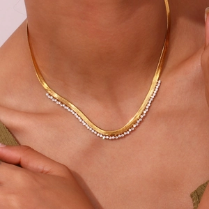 Close-up of gold-plated flat herringbone chain necklace with micro-paved cubic zirconia