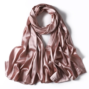 Detailed view of the smooth, lustrous texture of a pink satin scarf with soft folds