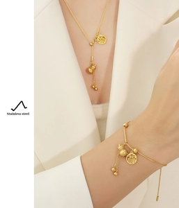Detail of 18k gold plated stainless steel necklace and bracelet set with gourd and Fu pendant