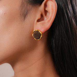 Close-up of a model wearing a vintage gold-edged flocked geometric round stud earring