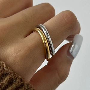 Minimalist double layer gold and silver stacked ring worn on finger, polished finish