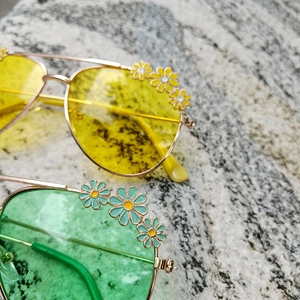 Detail of floral daisy frames and colorful lenses on stylish metal kids sunglasses