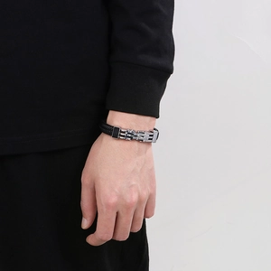 Primo piano del bracciale in pelle intrecciata da uomo con chiusura magnetica d'argento