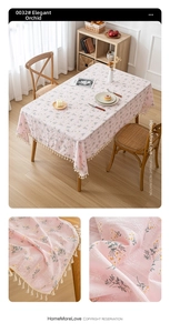 Detail of light pink floral tablecloth with cotton linen texture and cream ball fringe