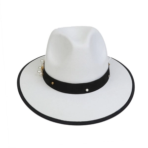 Detailed view of white felt fedora hat featuring pearl and metal stud decorative band