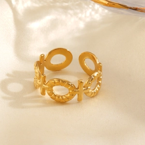 Verstellbarer goldener Edelstahlring mit Kreuzmuster auf warmem Seidenhintergrund
