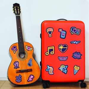 Neon style stickers with music and heart icons on a guitar and red suitcase