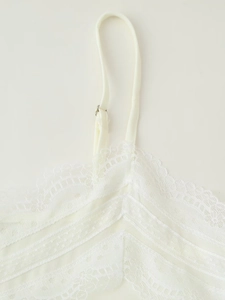 Close-up of white lace camisole showing delicate mesh texture and adjustable straps