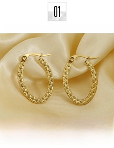 Detailed close-up of oval titanium steel gold earrings with unique honeycomb texture