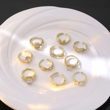 Flat lay of gold mixed rings with heart and rabbit designs on a white ceramic plate