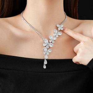 Macro shot of silver flower necklace featuring sparkling zircon clusters and teardrop pendant
