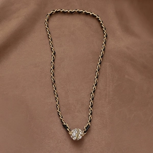 Elegant black leather woven chain necklace featuring a crystal-encrusted gold ball pendant