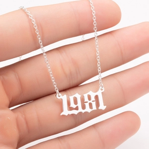 Detailed close-up of 1981 gothic font year pendant on a polished stainless steel chain