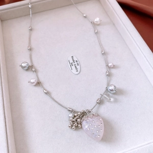 Detailed shot of pink strawberry pendant with rhinestones and elegant pearls on silver chain