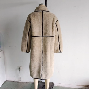 Vista posteriore dettagliata di un cappotto lungo in ecopelliccia beige con cuciture