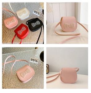 Detail of pink mini shoulder bag for girls featuring bow knot and pearl decorations