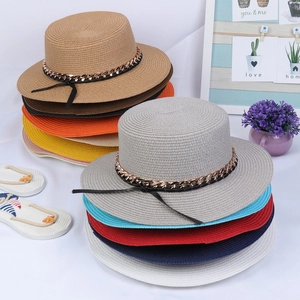 Detail of colorful straw hats with gold metal chains and black bands for summer