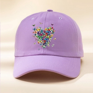 Dettaglio della stampa a cuore con farfalle colorate sul berretto da baseball viola