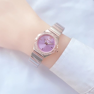 Close-up of a women's watch with purple sunray dial and rhinestone bezel on wrist