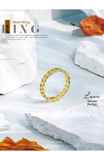 Detail of minimalist gold heart hollow ring on a textured stone aesthetic background
