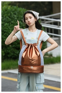 Detail of metallic bronze drawstring bag with mesh pockets and zip shoe compartment