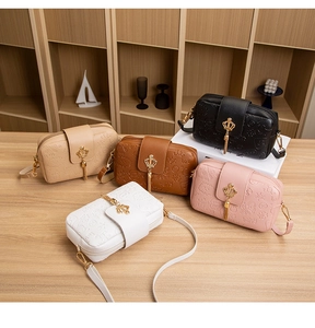 Detailed close-up of small floral embossed crossbody bags in five elegant pastel colors