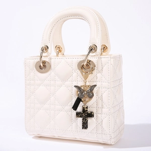 White quilted faux leather handbag with tassel butterfly and cross pendant charms