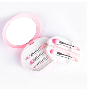 Detail of 5-piece travel makeup brush set with built-in mirror inside a pink storage case