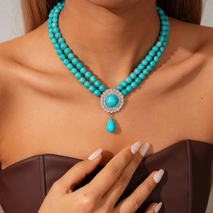 Detail of bohemian double-layer necklace with blue turquoise beads and crystal pendant