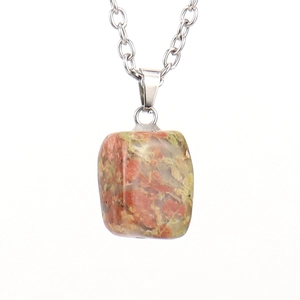 Macro detail of natural unakite stone pendant with red and green mineral textures
