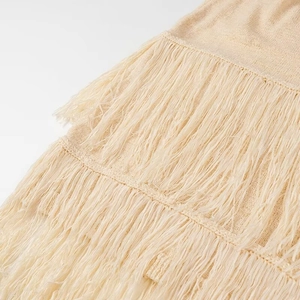 Dettaglio ravvicinato di frange beige a strati su un morbido tessuto a maglia fine