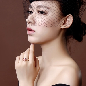 Elegant 18K rose gold ring with pink gemstone showcased on a model wearing black lace veil