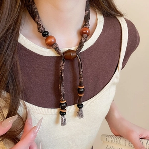 Détail du collier ethnique rétro avec perles en bois et sangle en tissu à fleurs