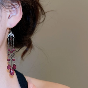 Détail de boucles d'oreilles franges en cristal violet avec accents de diamants brillants