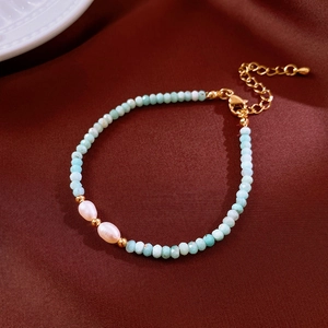 Macro view of blue amazonite faceted beads and pearls on dark red silk fabric