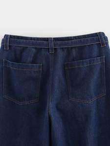 Vue détaillée du dos d'un jean avec coutures orange, deux poches et passants de ceinture