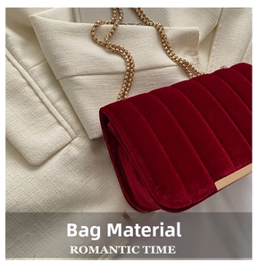 Close-up of dark red velvet fabric with vertical quilting and elegant gold chain detail