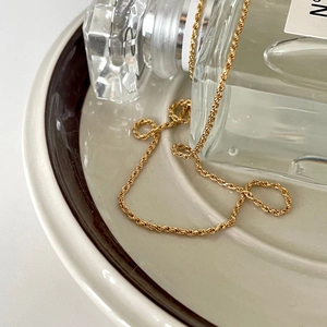 Elegant 925 sterling silver gold shell necklace on a cream ceramic plate with glass decor