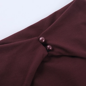 Detailed macro view of burgundy knit fabric and matching covered buttons on backless top