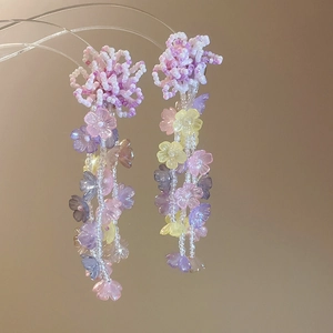 Primer plano de pendientes de flores de cristal de colores con cuentas en tonos pastel