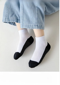Detail of white cotton sports socks with black heel and toe featuring breathable mesh texture