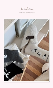 Détail de chaussettes mouton en gris et blanc avec des chaussons en peluche