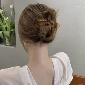 Close-up of a tortoiseshell hair clip styled on a woman's hair for an elegant bun look