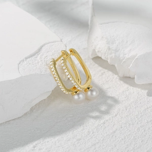 Detail of gold S925 silver pearl drop earrings with micro-inlaid cubic zirconia stones