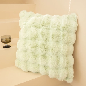 Detail of mint green faux fur blanket with textured plush surface on minimalist decor