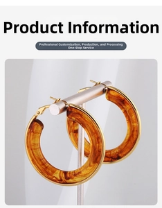 Detailed close-up of tortoise shell resin hoop earrings with elegant golden metal borders