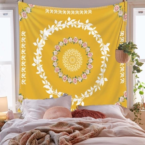 Detail of bohemian yellow mandala tapestry with floral leaf patterns in a cozy bedroom