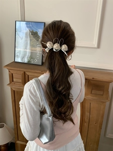 Vue détaillée d'une pince à cheveux avec roses en soie et rubans sur une coiffure