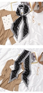 Macro detail of French style long silk scarf with white script pattern on black fabric