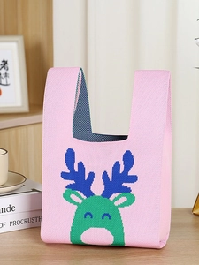 Pink knitted Christmas tote bag with cartoon reindeer pattern in a cozy lifestyle setting